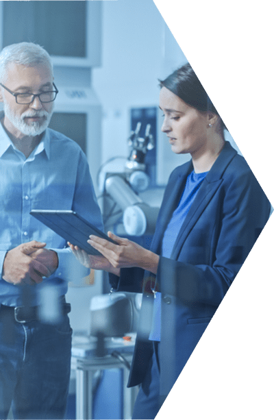 engineering-capabilities-cta Two business professionals standing side by side in a lab and both looking down at a tablet.