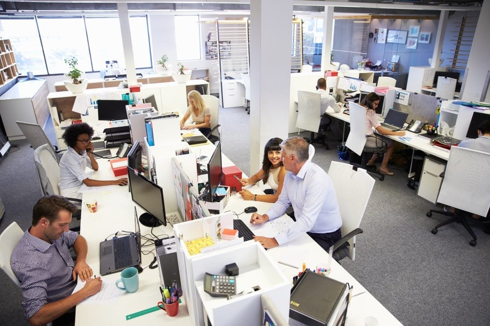 An open concept office environment with employees working side by side with their peers