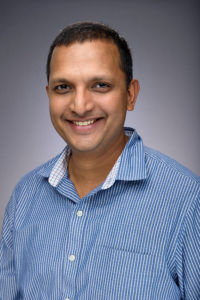 Headshot of George Zacharia wearing a blue collared shirt