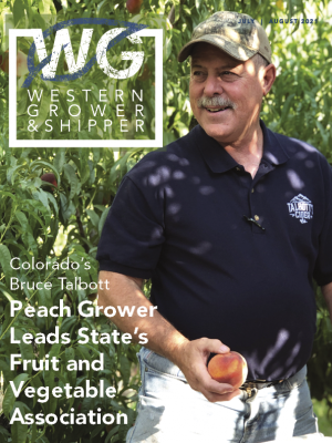 Farmer holds a peach photographed in an orchard, cover of WGA Magazine