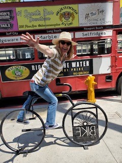 Michille Watson on a bike waving