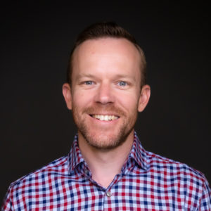 headshot of Jason in plaid collared shirt