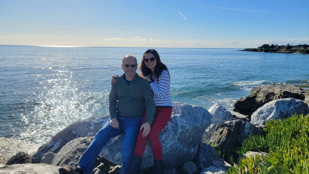 Bob and his wife standing in front of the ocean